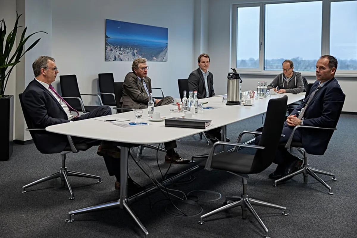 Fünf Männer an einem Konferenztisch im Besprechungsraum